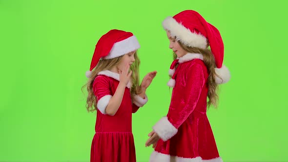 Children in Red Suits Play New Year's Games, Smile and Have Fun. Green Screen