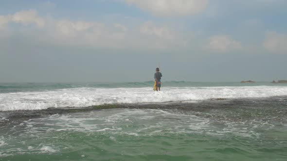 Aged Fisherman Silhouette Stands in Deep Blue Ocean Water