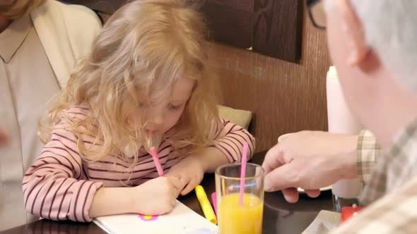 Little Girl Drawing with Grandparents