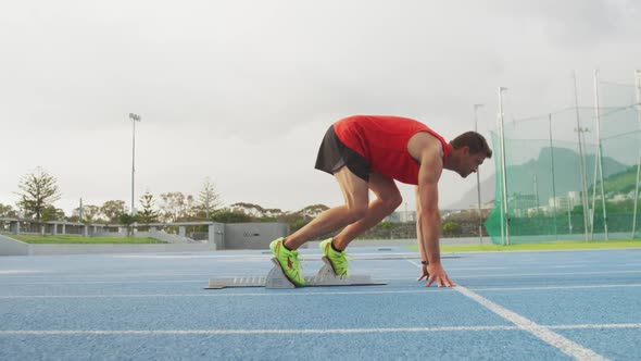 Caucasian athlete running in stadium