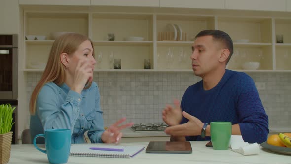 Attractive Couple with Hearing Loss Managing Family Finances in Kitchen