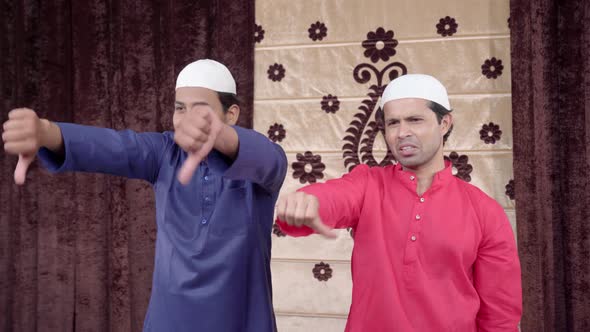 Two Muslim men showing thumbs down