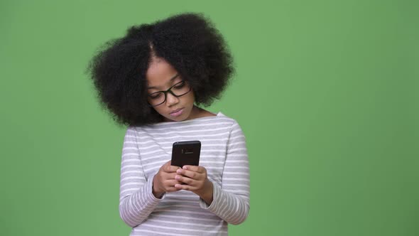 Young Cute African Girl with Afro Hair Using Phone