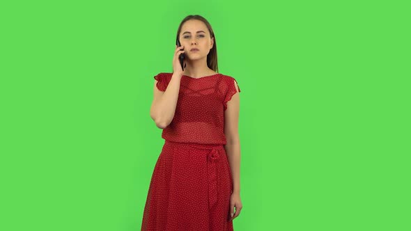 Tender Girl in Red Dress Is Talking for Mobile. Green Screen