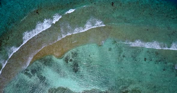 Wide fly over travel shot of a white paradise beach and blue ocean background in hi res 4K