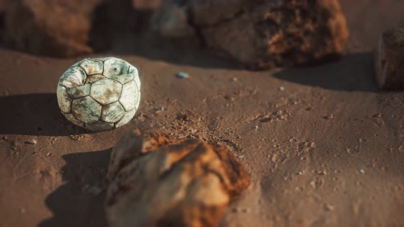 Old Football Ball on the Sand Beach