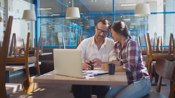 Young Happy Couple Cafe Owners Reading E-mails From Food Suppliers on Laptop Screen