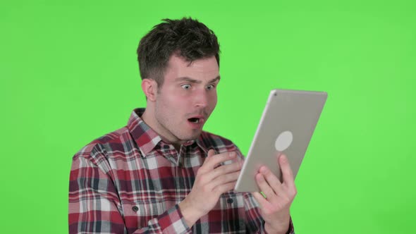 Portrait of Young Man Reacting to Loss on Tablet Green Chroma Screen