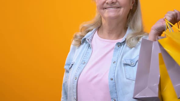 Mature Woman With Shopping Bags Holding Dollar Bills, Purchase Payment, Credit