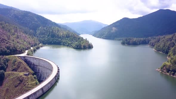 Beautiful Aerial Drone Shot Slowly Revealing the Side of a Mountainside Dam.