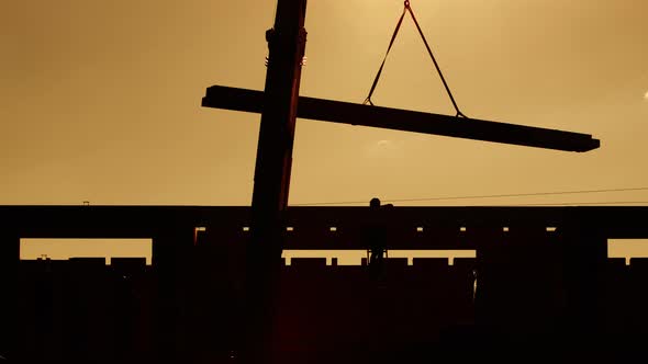 Silhouette of Beams Hooked Onto the Crane at Sunset