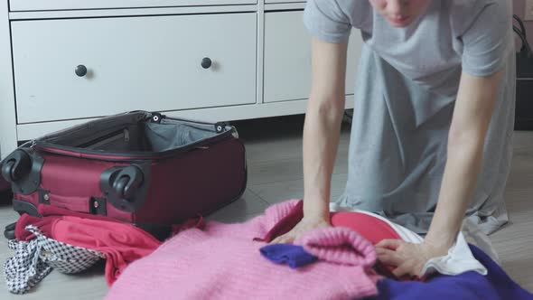 Caucasian Female Hands Packing Folding Colorful Warm Clothes Sweaters on Floor