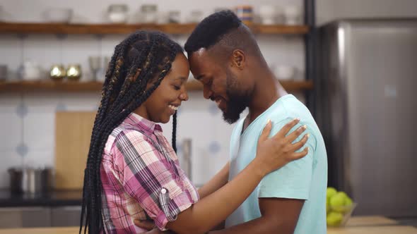 Happy Afroamerican Young Couple Embracing and Smiling in Modern Kitchen