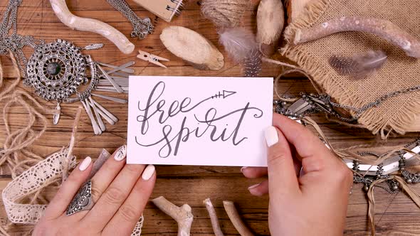 Hand with FREE SPIRIT card over a wooden table top view