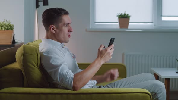 Excited Overjoyed Man Winner Celebrating Success Looking at Smartphone and Making Yes Gesture