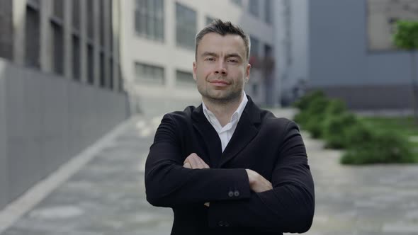 Crop View of Mature Businessman Crossing Arms and Looking To Camera