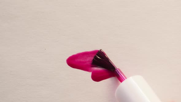 Smearing Pink Nail Polish on White Background