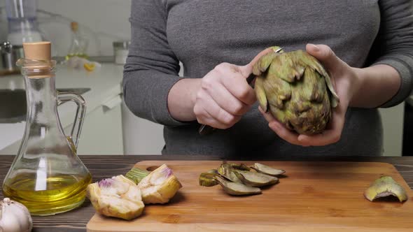 Woman Cleaning Artichokes with Knife