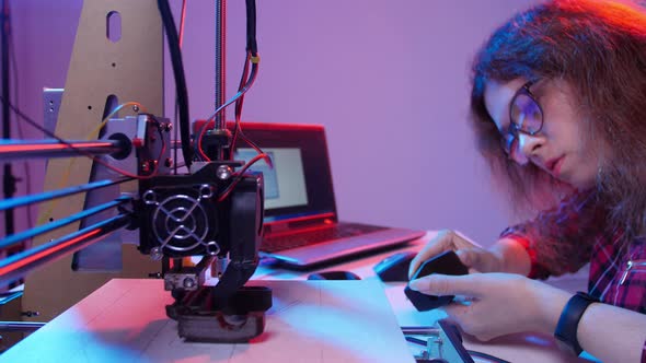 Concept of Modern Production Technologies. Young Woman Student Makes the Item on the 3D Printer