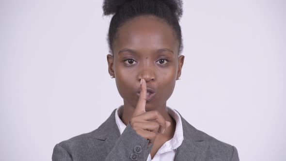 Face of Young African Businesswoman with Finger on Lips