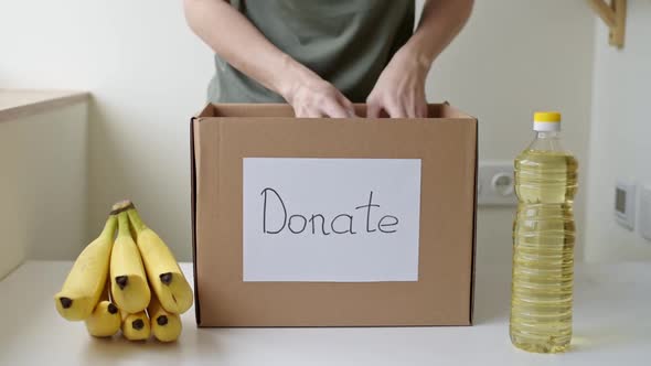 Woman Takes Out Food Products From Donation Box