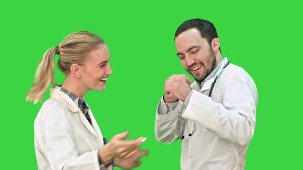 Happy Young Doctors Wearing White Medical Overall Dancing on a Green Screen, Chroma Key.