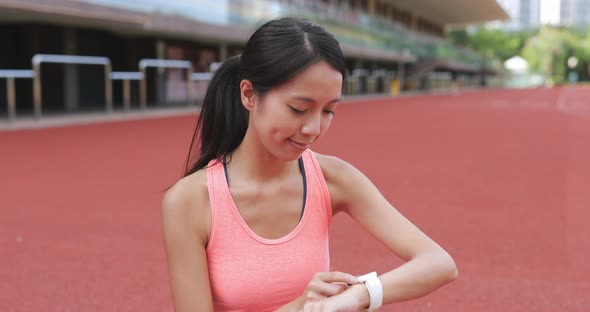 Sport woman using smart watch in sport stadium 