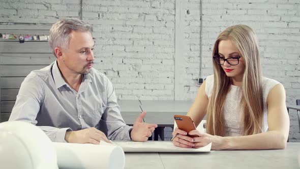 Young Woman and Man Colleagues Talking While Working on Startup Project in Office