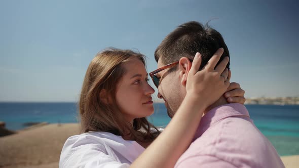 Romantic Date Near Sea Man and Woman are Hugging on Top of Cliff with Sea View