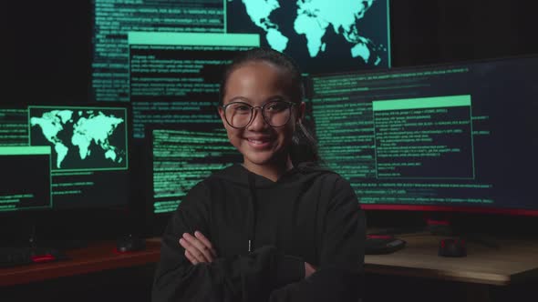 Asian Young Girl Hacker Hacking With Multiple Computer Screens And Pose With With Arms Crossed