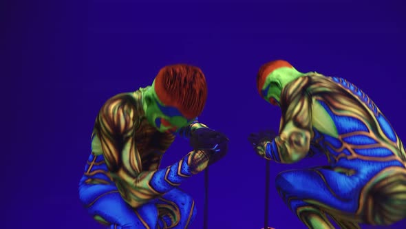 Beautiful Young Twins In Luminous Body Art In The Style Of Aliens. On A Blue Background