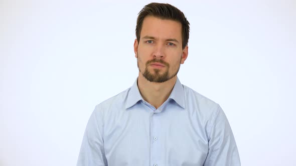 A Young Handsome Man Looks Seriously at the Camera - White Screen Studio