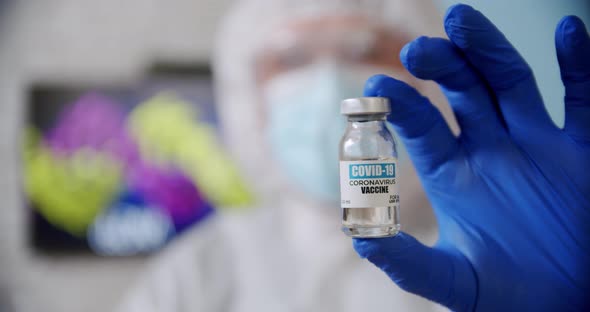 Blured Doctor's Hand Holds Ampoule Vaccine Bottle at the Hospital