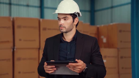 Factory Manager Using Tablet Computer in Warehouse or Factory