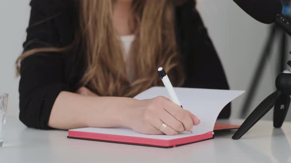 Young blond woman Records a podcast, lecture, or webinar on a dictaphone.