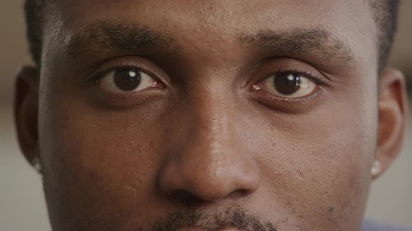 Close Up of Two Eyes of an African American Man Looking Into Camera and Blinking and Shaking His