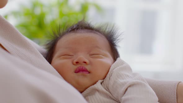 Adorable sleeping newborn baby relax in mother arm safety and comfortable