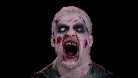 Sinister Man Halloween Crazy Zombie with Bloody Wounded Scars Face Trying to Scare on Black Room