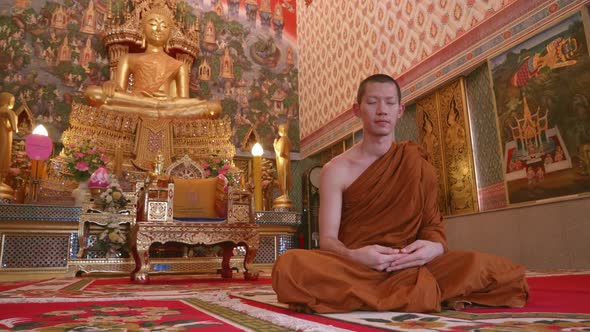 The monks were meditating in the church with calm and beautiful art and Buddha images. Slow motion.