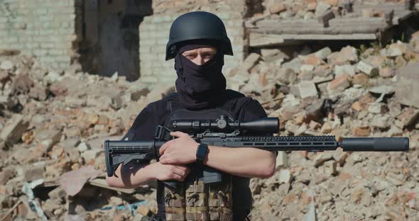 A Ukrainian Soldier Picks Up His Rifle and Looks Around