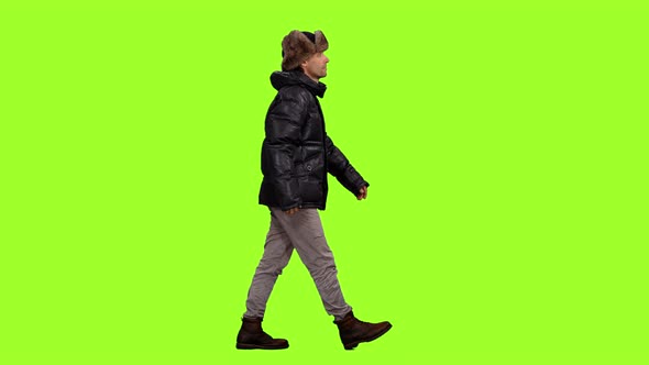 A Man in Winter Clothes Walks on Green Background, Chroma Key