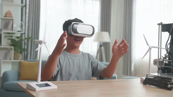 Asian Boy Wearing VR Glasses While Experimenting With Wind Turbine Model At Home