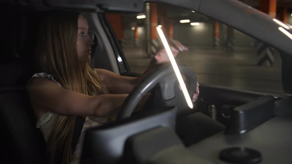 Blonde Female Driving Car in Supermarket Parking