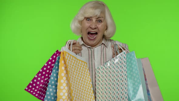 Senior Grandmother Raising Shopping Bags, Celebrating, Satisfied with Purchase, Discount. Chroma Key