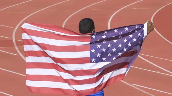 Sportsman holding flag of USA showing his victory in international competition