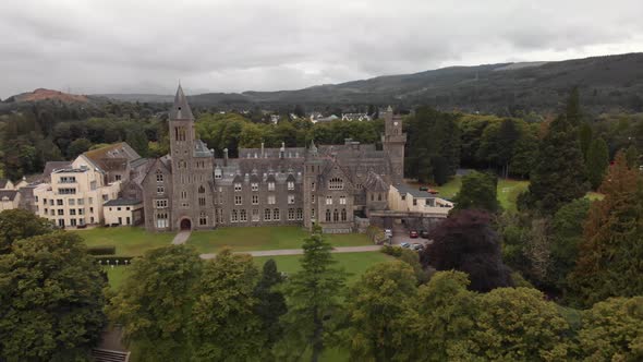 Dramatic aerial reveal of Fort Augustus Abbey on shore of Loch Ness, Scotland