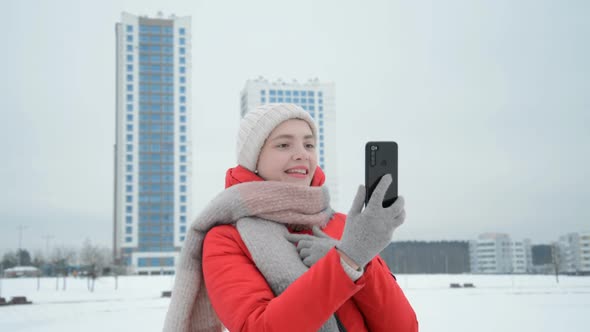 A Girl Funny Talking on Smartphone By Video Chat on Urban Background