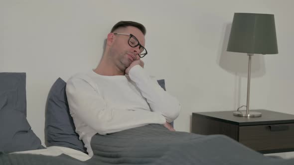 Sleepy Casual Man Taking Nap While Sitting in Bed