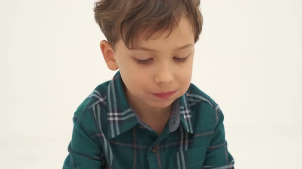 Boy with Slightly Dirty Face is Eating Hot Dog