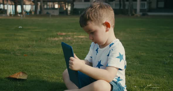 Curious Cute Baby Boy Preschool Child Using a Digital Tablet Technology Device Looks Telephone